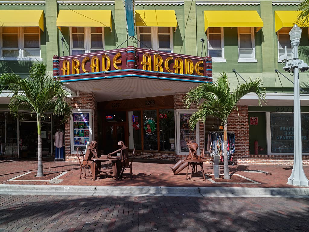 The Arcade Theatre and brick-paved First Street in downtown Fort Myers, Florida, with palms, awnings, and street furniture